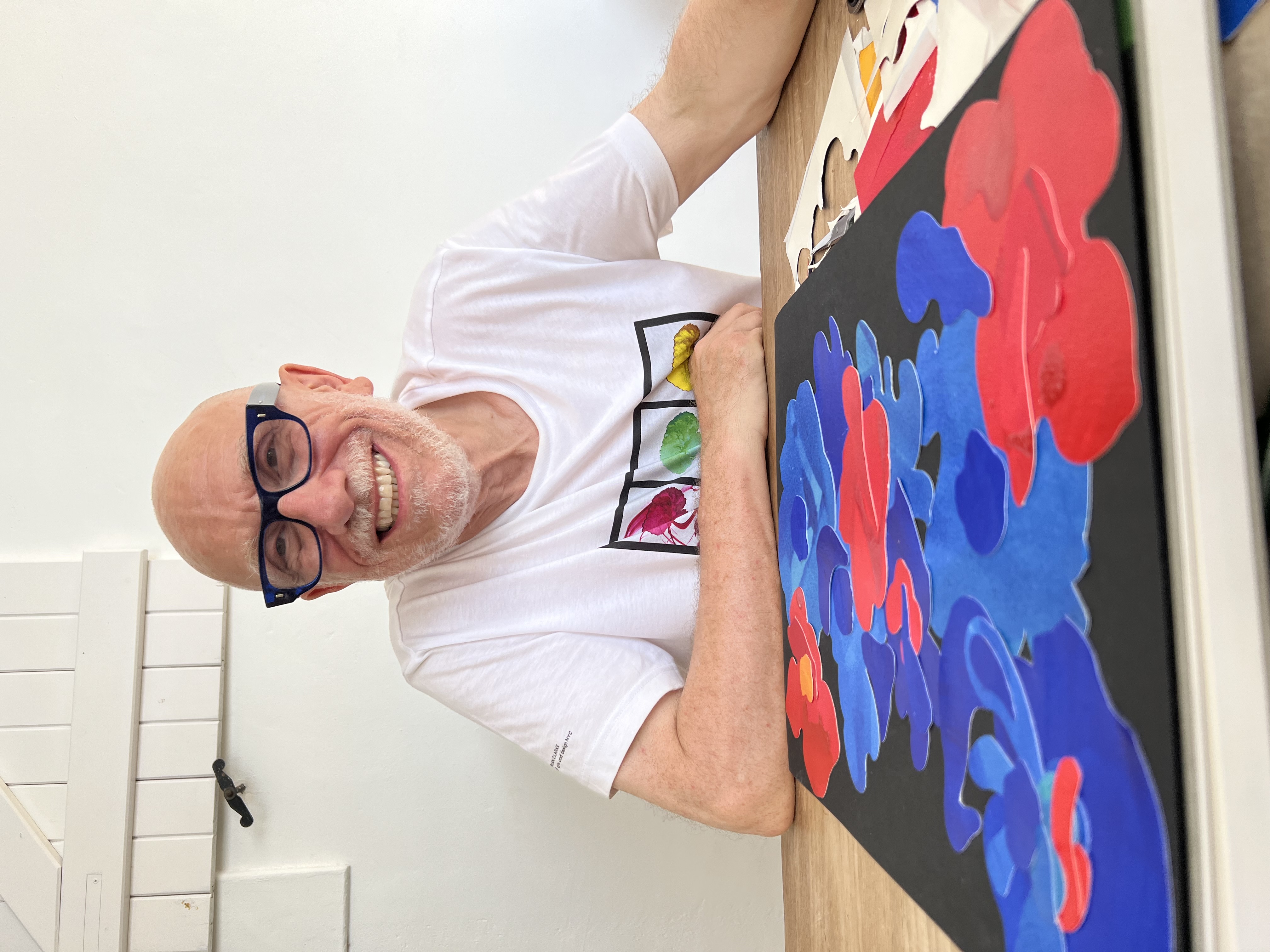 Sir Brian Clarke smiling with his art work