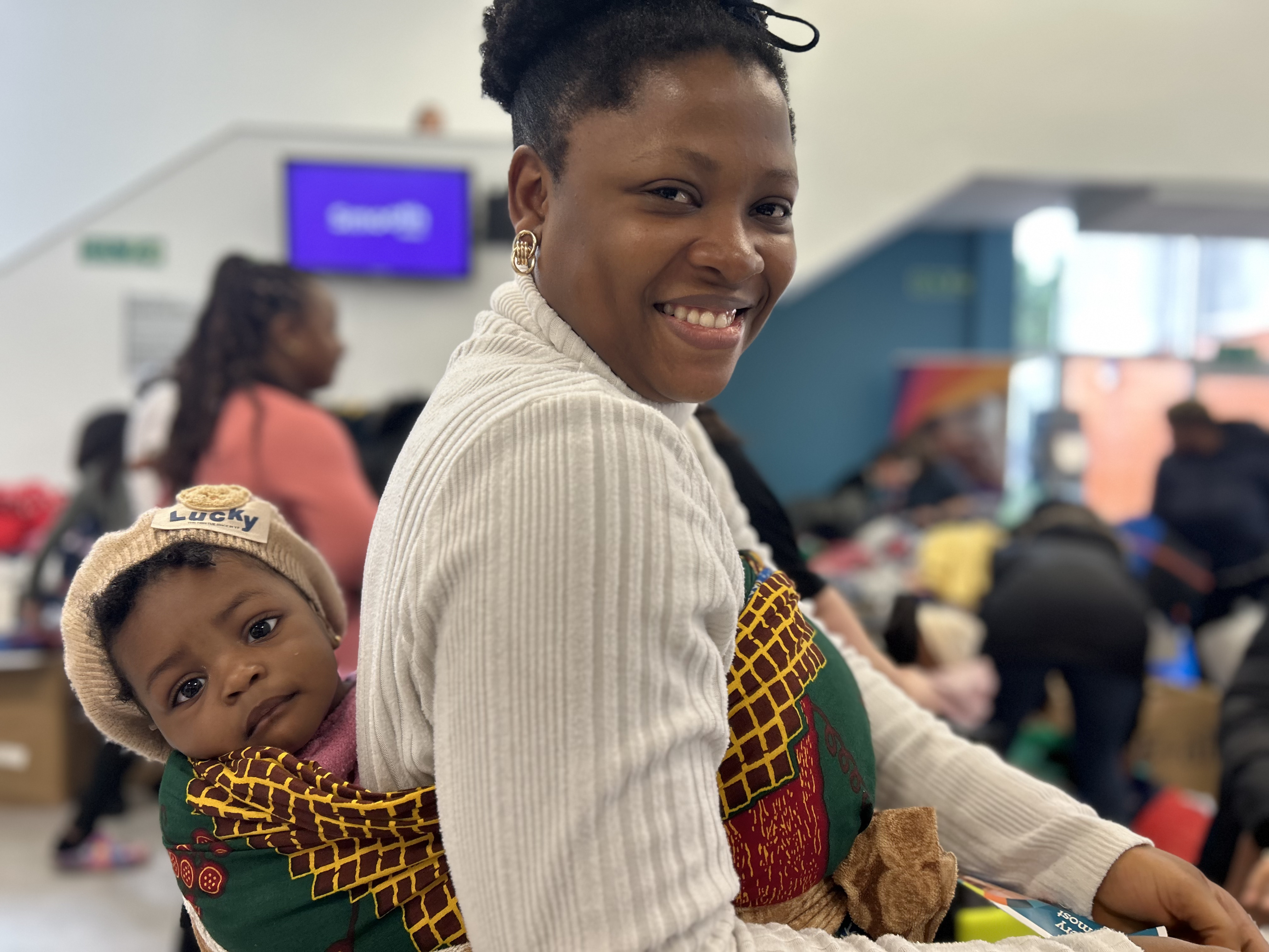 A mum and baby smiling at the Winter Warm Appeal drop-in