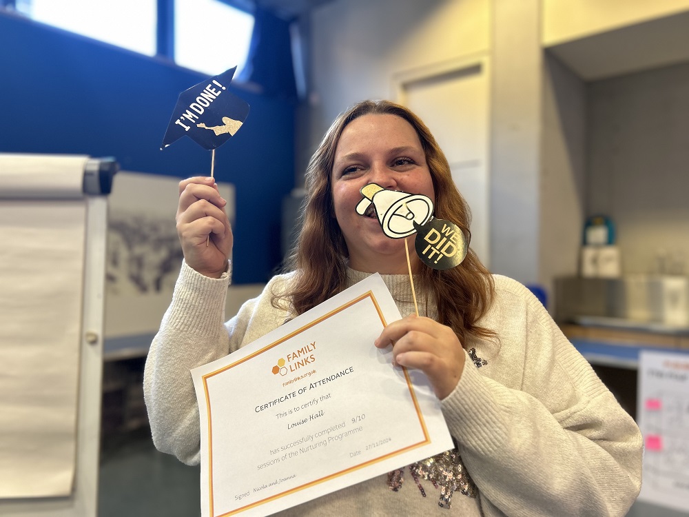 Mum Louise Hall celebrating as she holds up an 'I'm done' sign