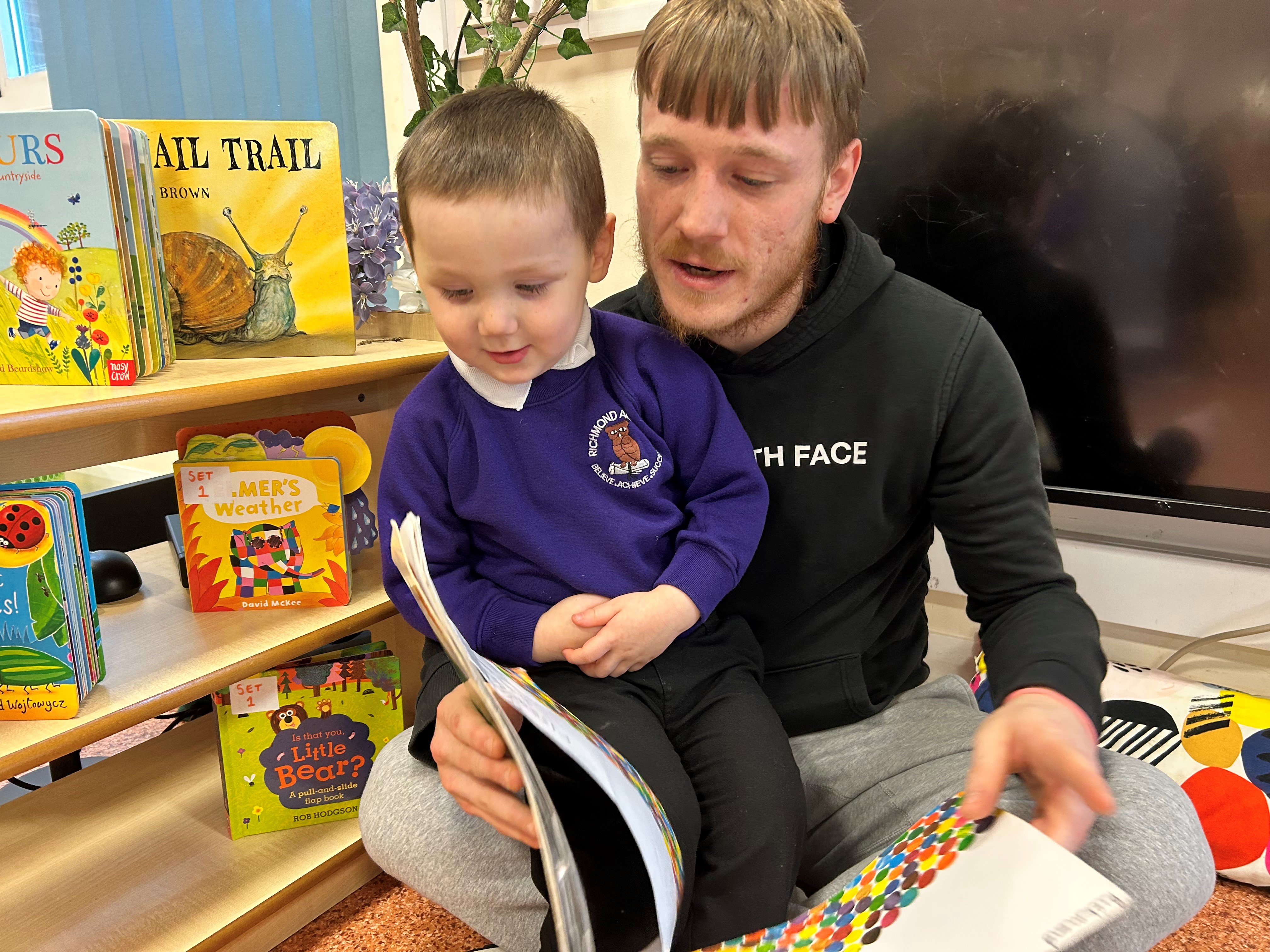 Dad Joshua and his son reading together